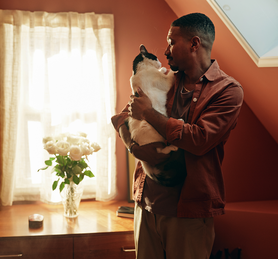 Red-haired woman working on a laptop at a table with a Dalmatian dog sitting beside her.