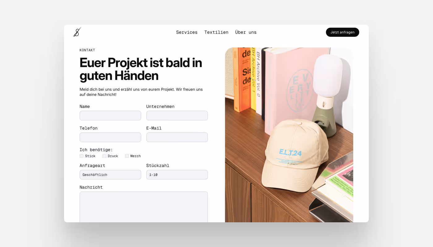 Screenshot of a contact form next to books, a lamp, and a beige cap on a desk.