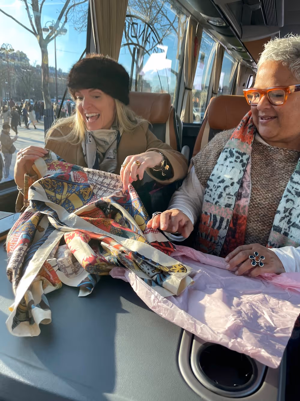 Members Georgia Zikas and Caren Rideau show each other their purchases on the way home from the flea market.