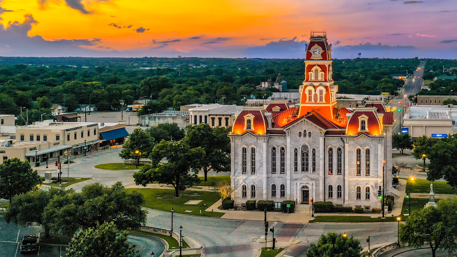 Historic Parker County Courthouse lit up at sunset with surrounding streets and greenery. Therapy Associates of Parker County TX