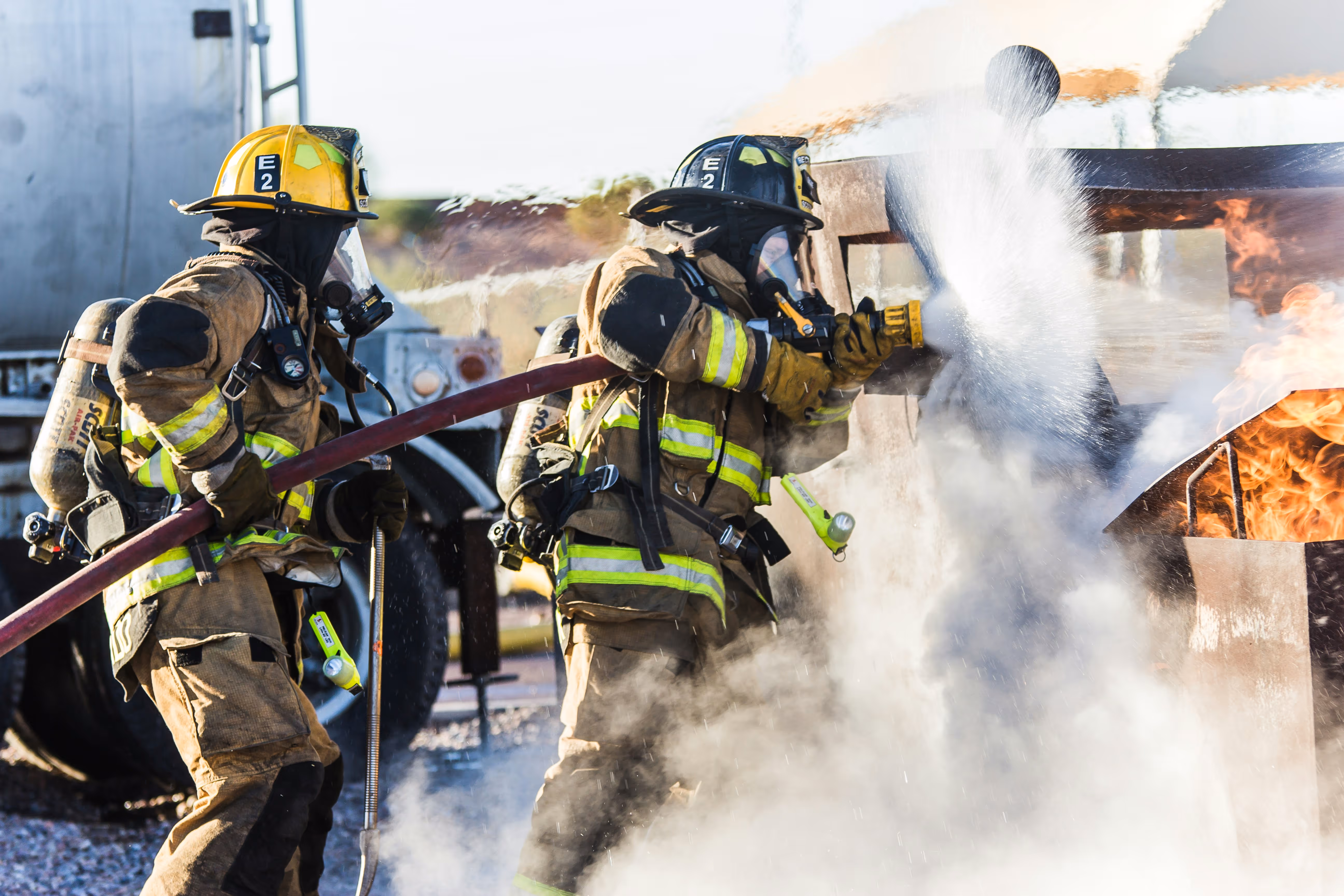 Two firefighters in full gear battling a structural fire, illustrating the high-stress environments that lead to PTSD in first responders. Specialized trauma and exposure therapy counseling are available at Therapy Associates of Parker County, serving police, fire, and EMS in Weatherford, Aledo, and the greater Parker County area.