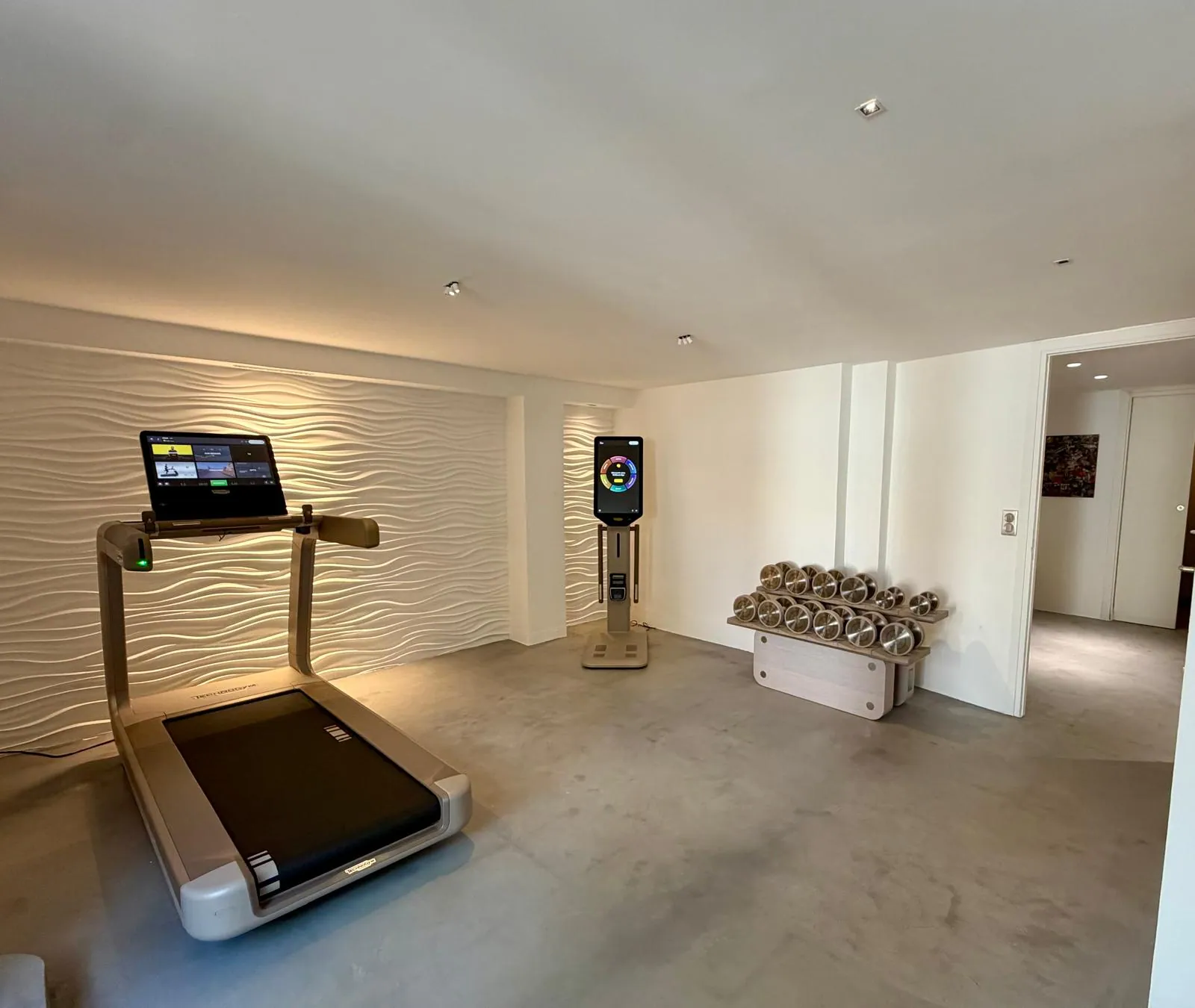 Espace fitness du showroom Nöje avec tapis de course et haltères