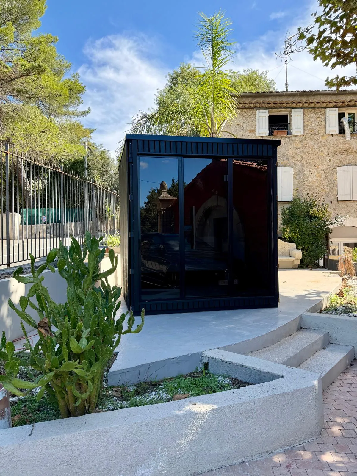 Cabine de sauna extérieur noire exposée devant le showroom Nöje à Mougins