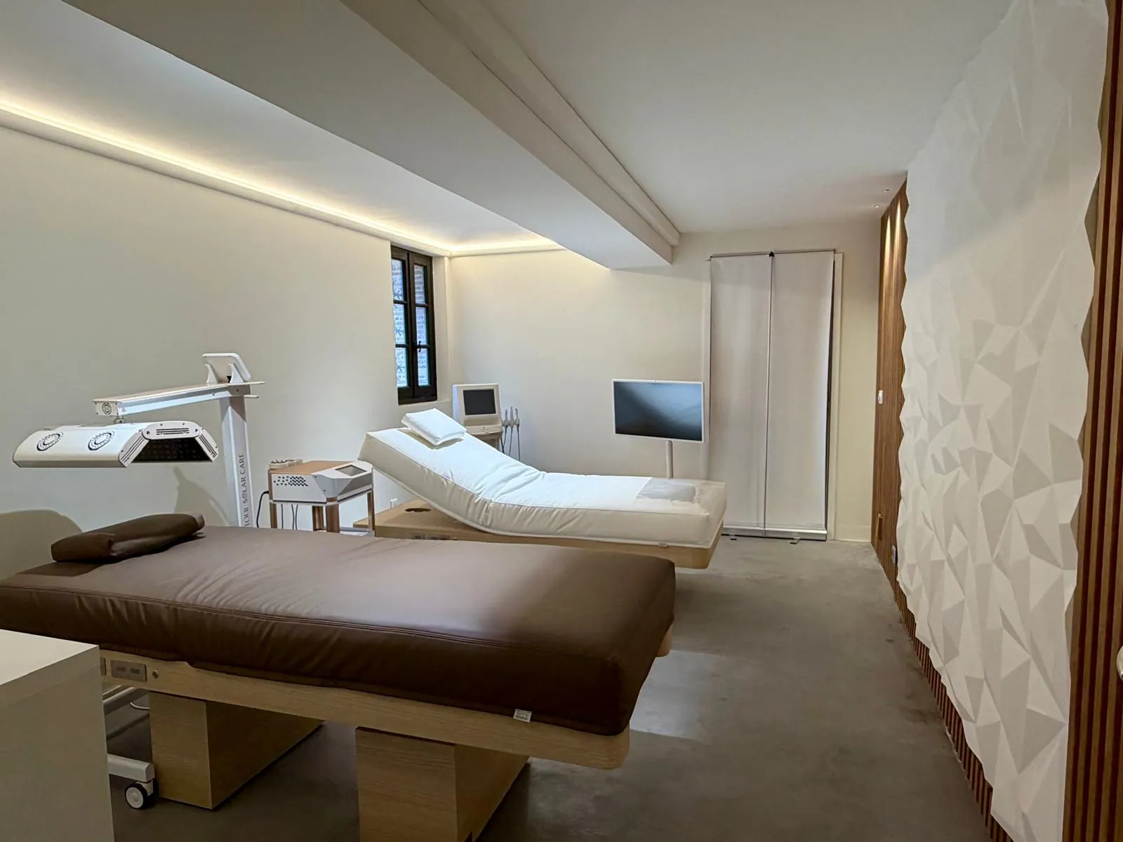 Tables de soin et mur texturé dans la salle de soins du showroom Nöje