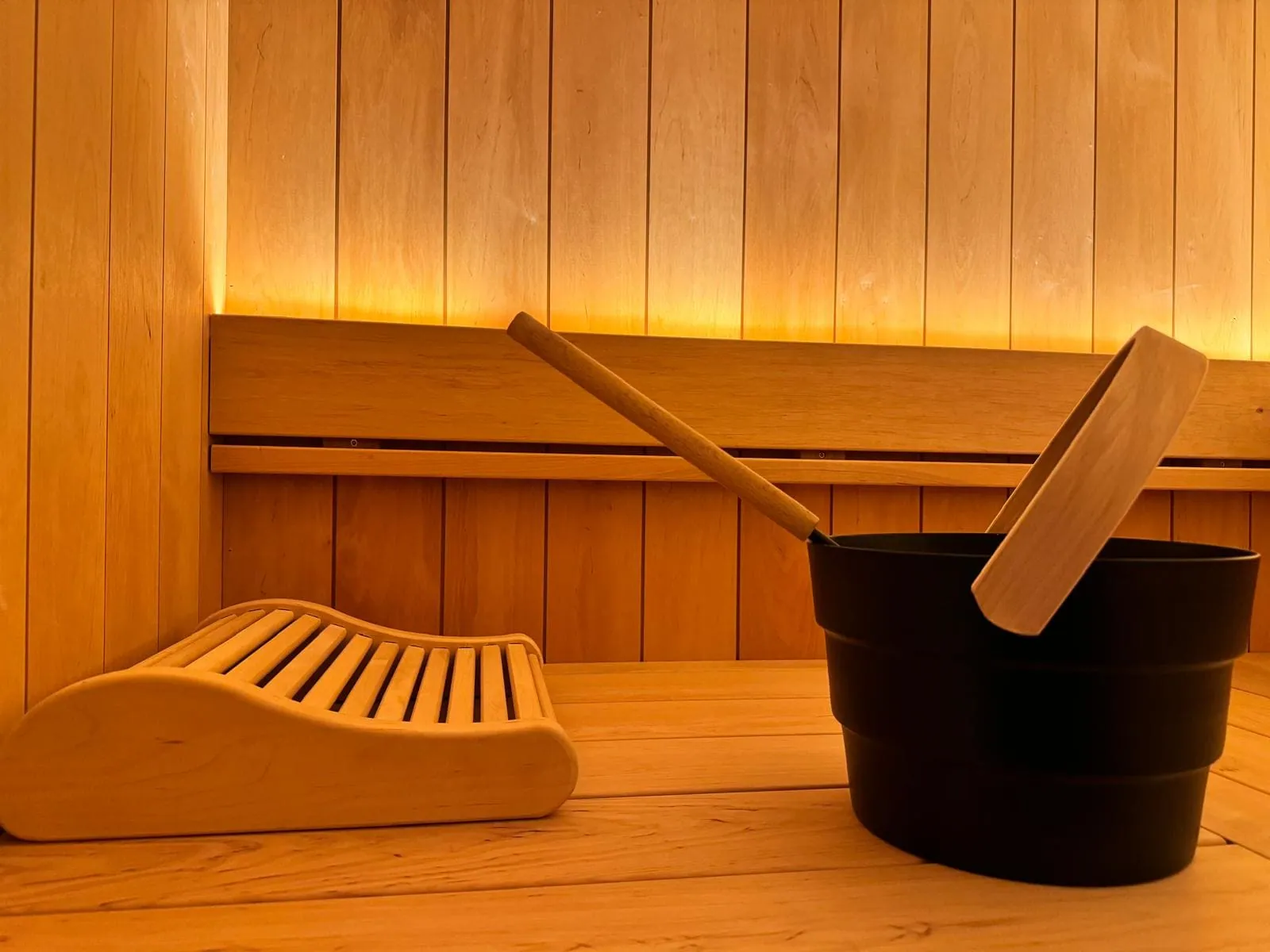 Intérieur de sauna finlandais en bois avec seau et louche, réalisé par Nöje
