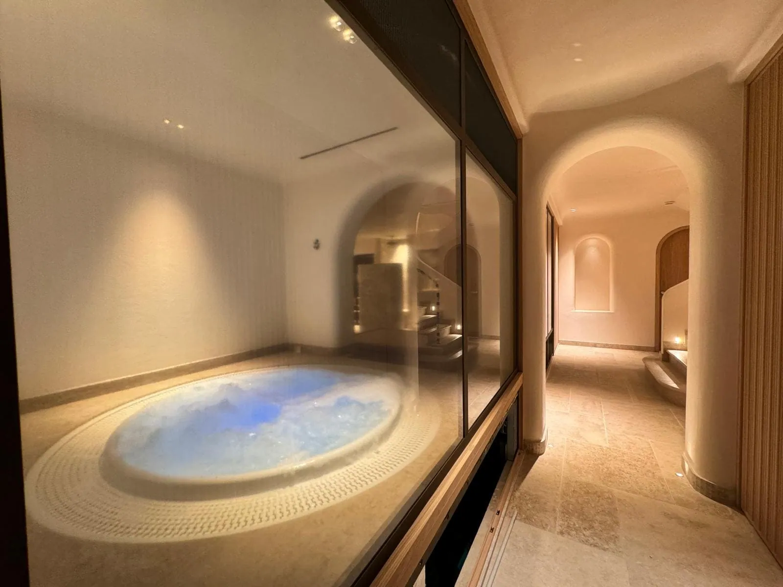 Espace bien-être aménagé par Nöje avec bassin, sauna et couloir en pierre