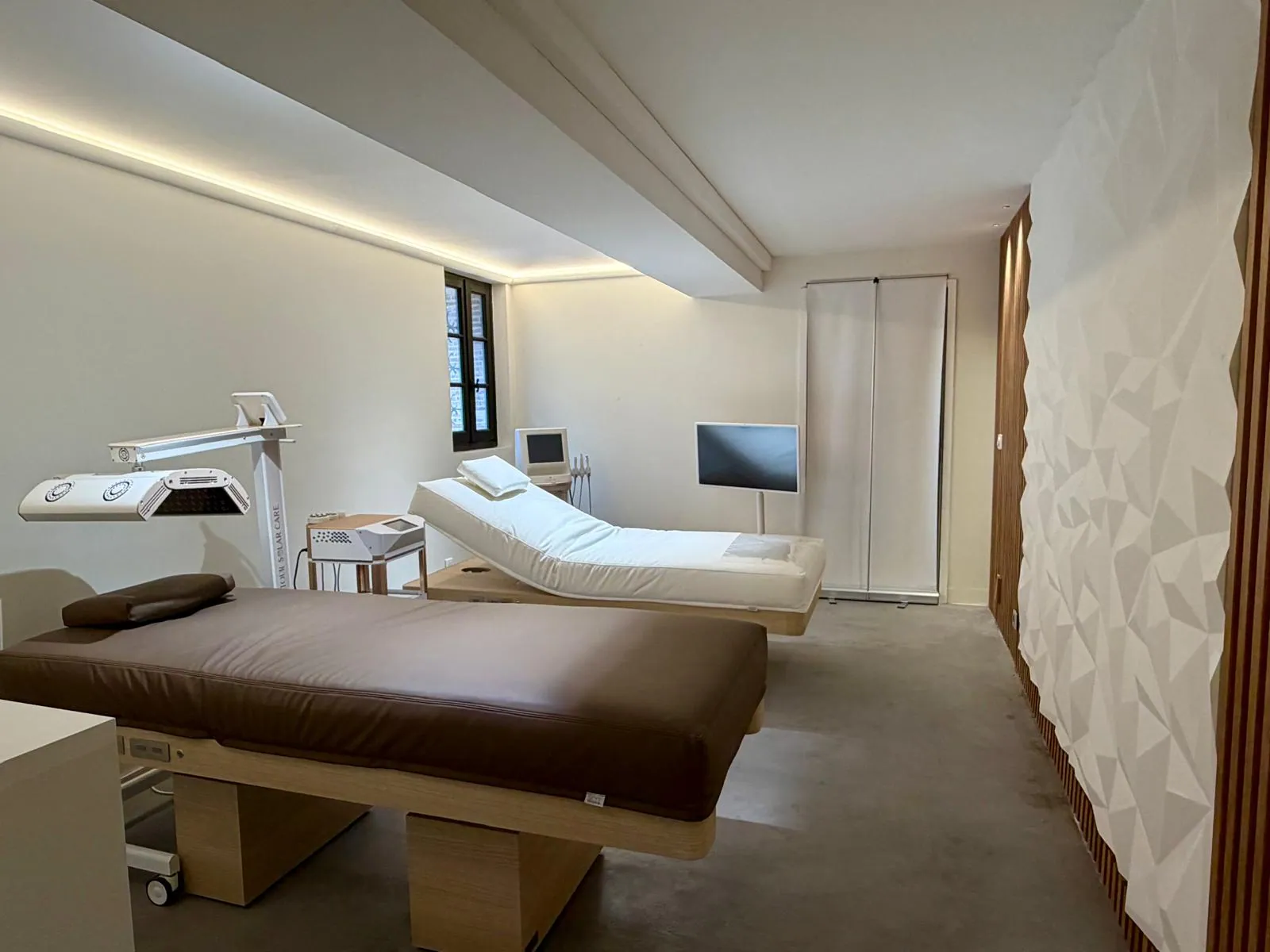 Salle de soins du showroom Nöje avec tables de massage et équipements spa