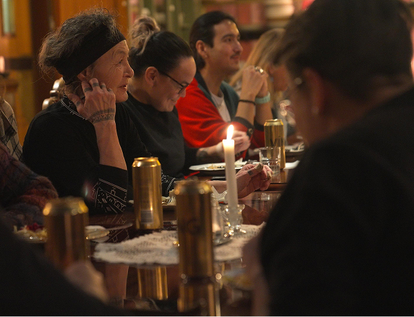 A group of Inuit people having dinner and laughing