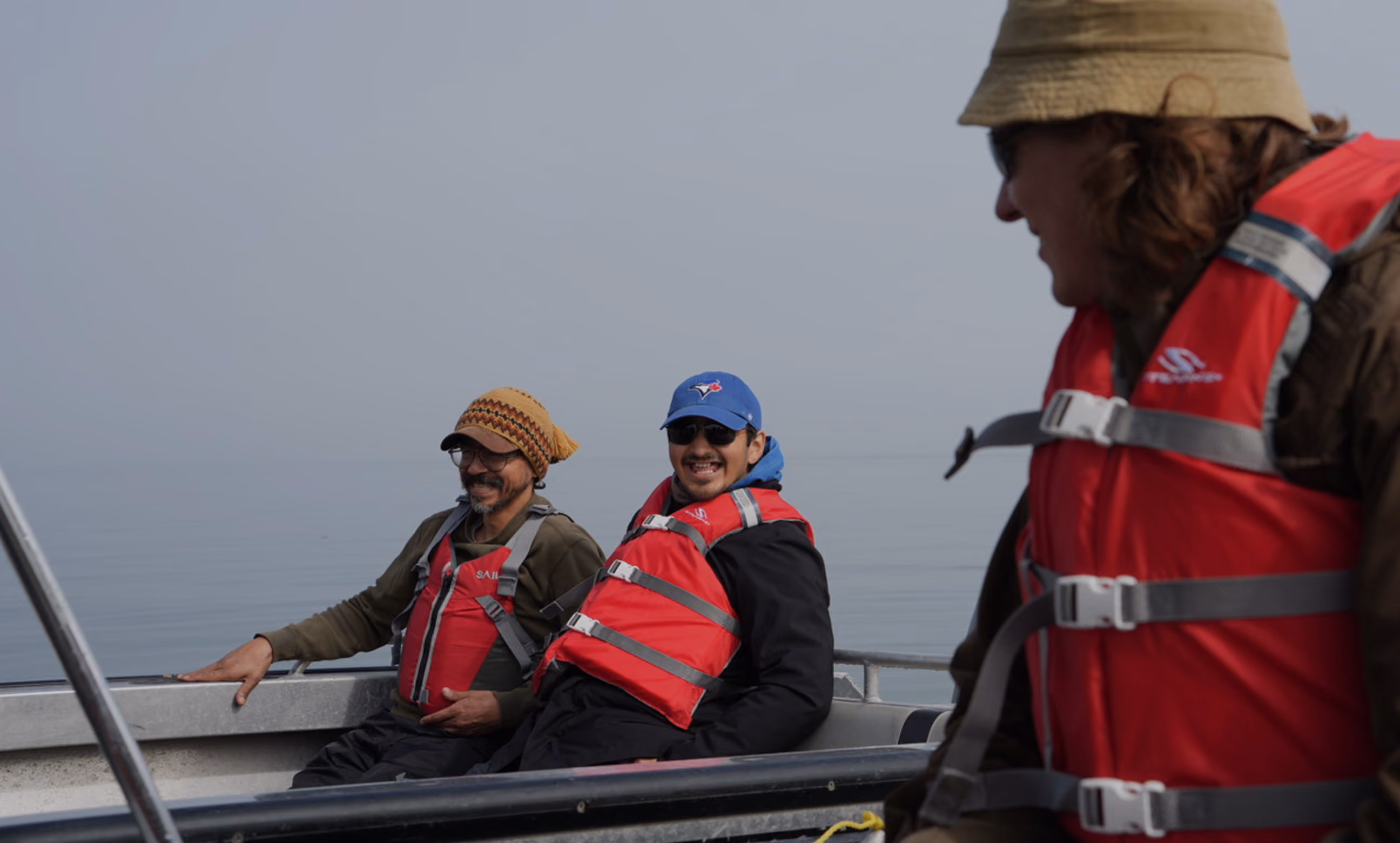 3 men smile on a boat