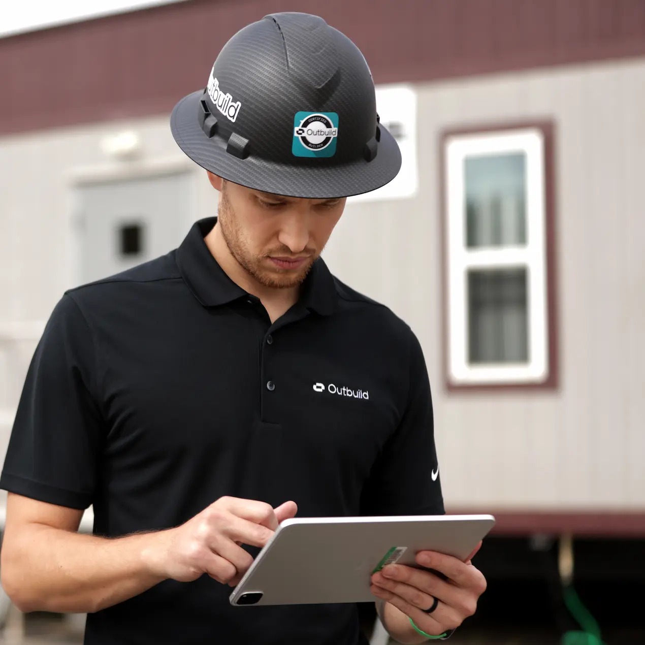 Mike from customer success at Outbuild using the iPad app next to a trailer