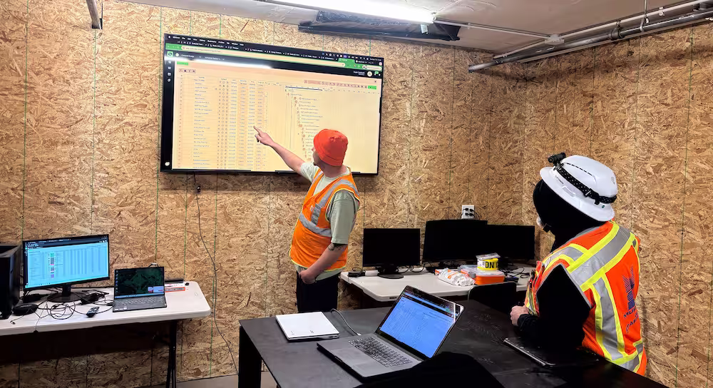 a construction jobsite team managing their construction schedule with Outbuild software