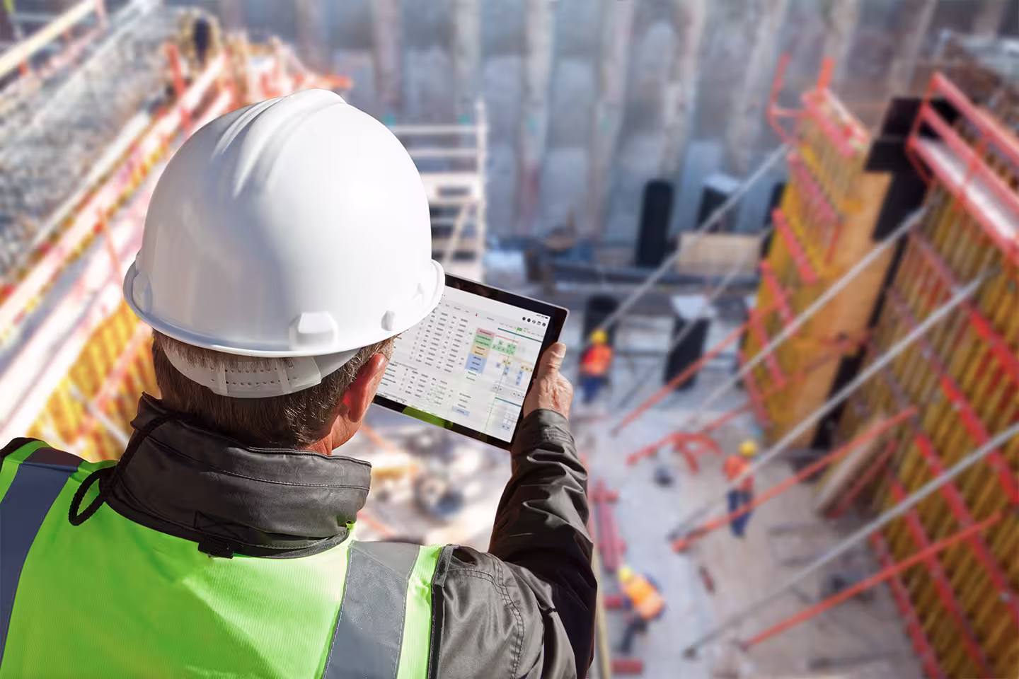 Construction worker reviewing schedule of complex project on iPad.