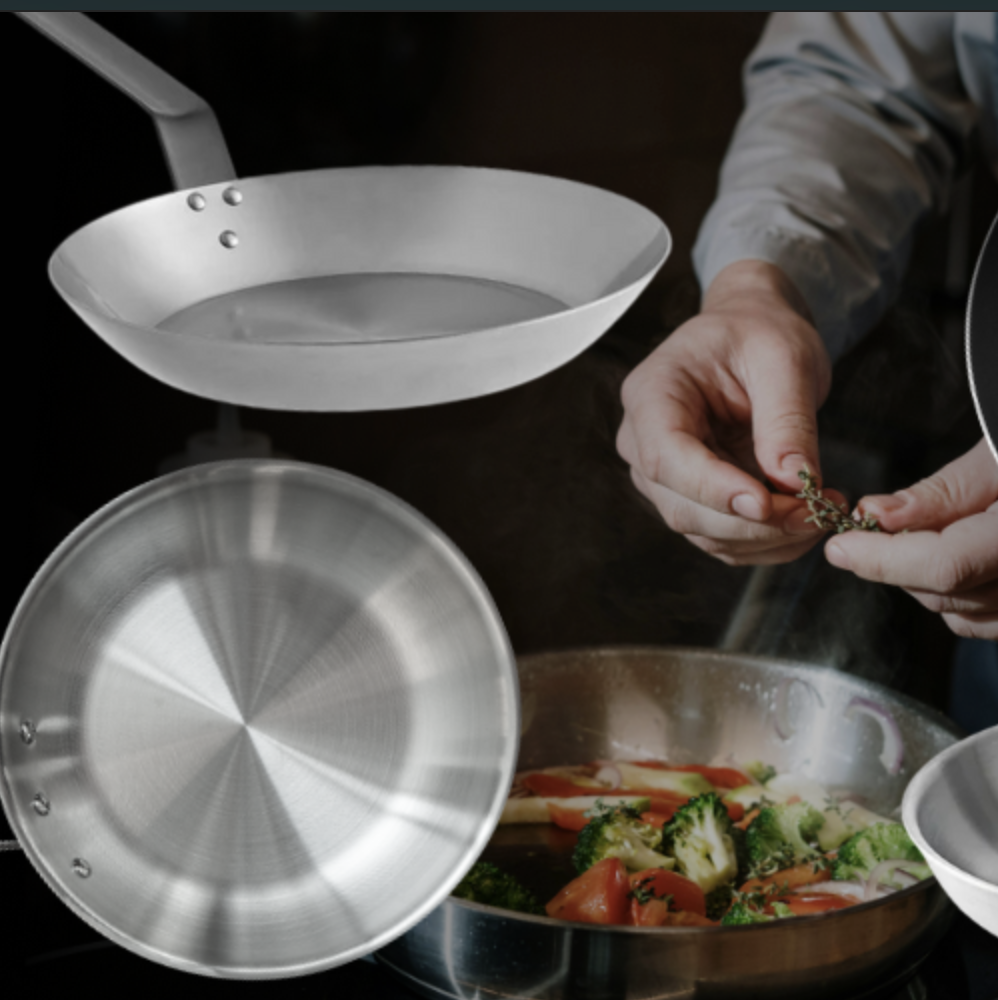 Different types of commercial cooking pans and skillets, including stainless steel, non-stick, and aluminum, with chef preparing vegetables.