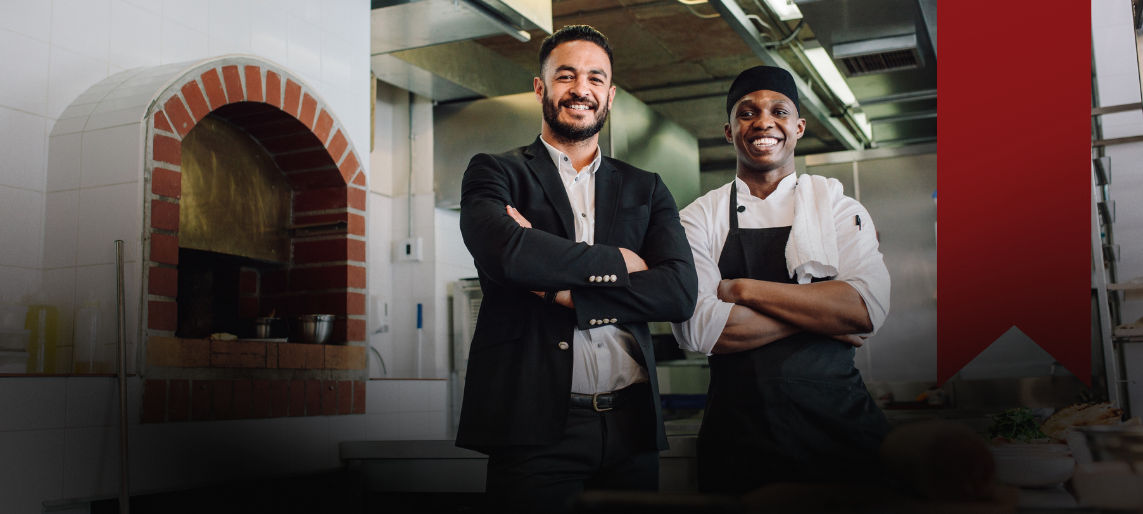 Chef and manager collaborating in a professional kitchen.