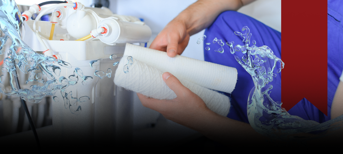 Technician replacing filters in a commercial water filtration system.