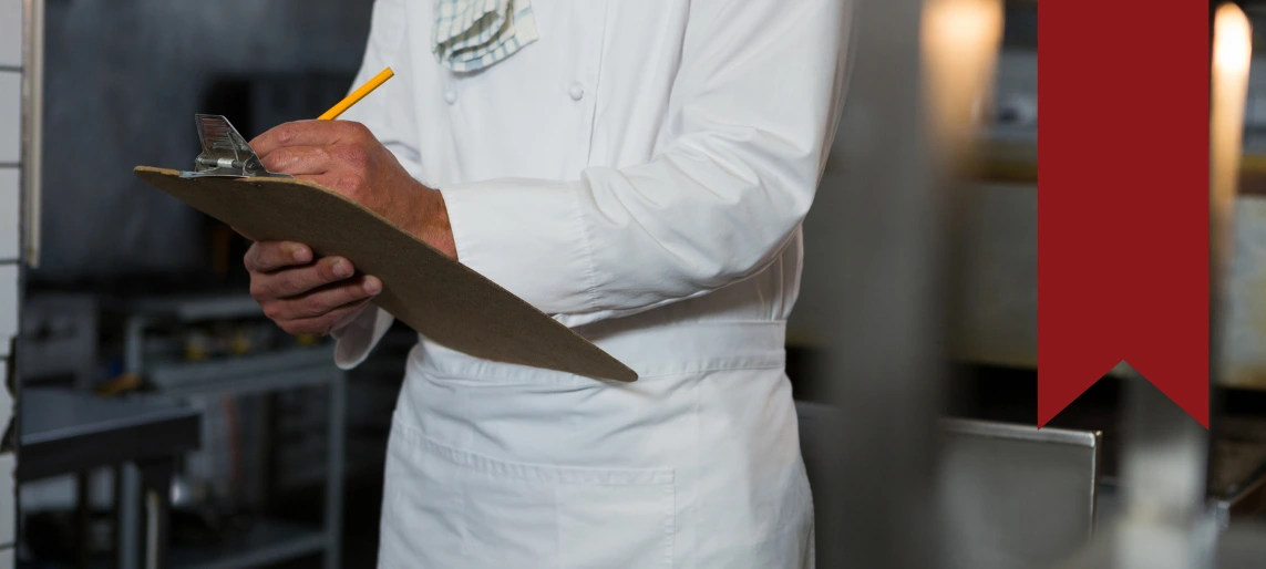 Cannabis kitchen supervisor reviewing safety checklist to ensure code compliance and proper documentation in a regulated food production environment with Aldevra.