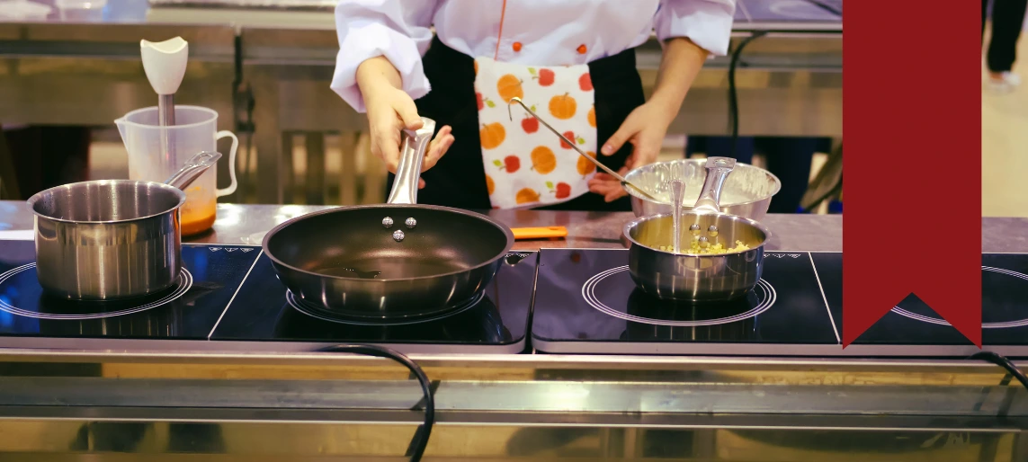 Cannabis kitchen operator using commercial induction cooktop for precise temperature control and consistent edible product quality supported by Aldevra.