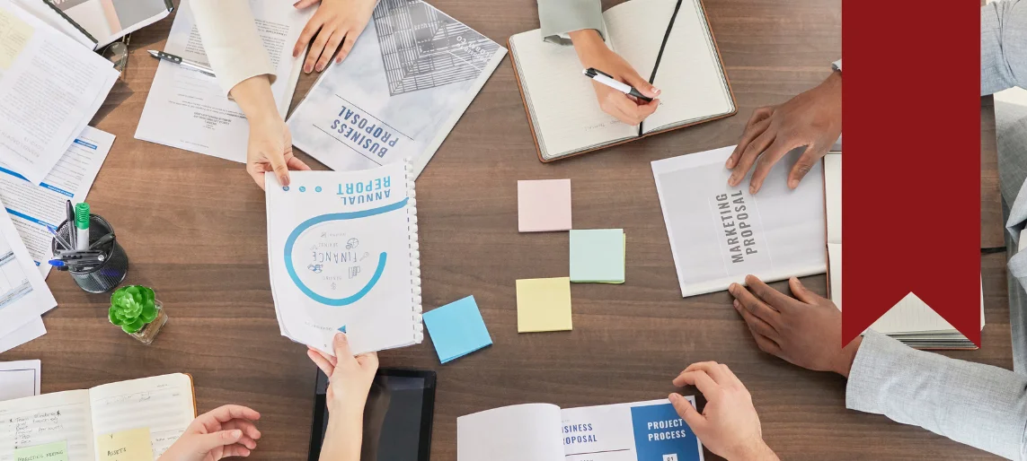 Community shared kitchen planning team reviewing business proposals, operational documents, and program development materials.