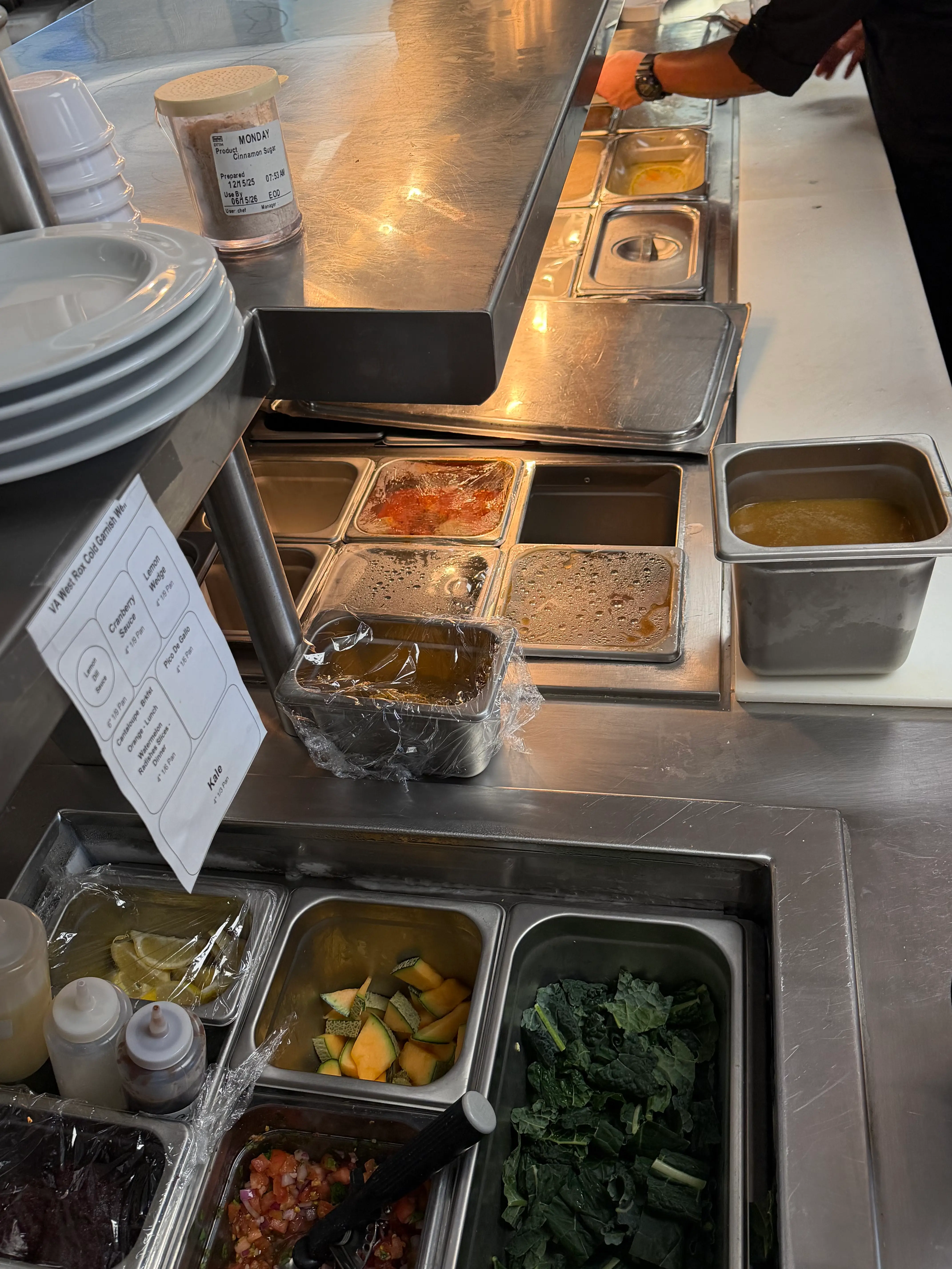 Hospital kitchen tray line with ingredient pans and warming drawers.