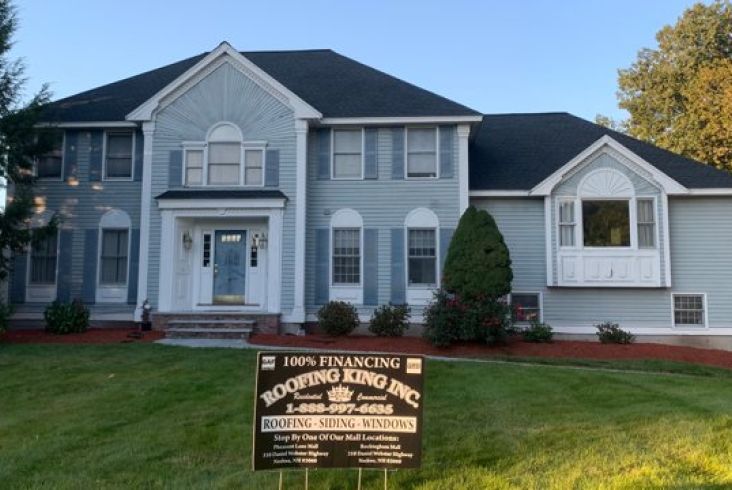 Grand house with a dark roof and well-maintained front lawn.