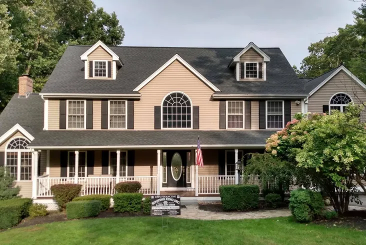 Large house with a welcoming porch and lush greenery.