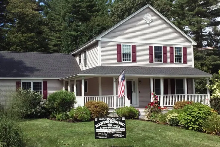 Two-story home with a dark roof and red shutters.