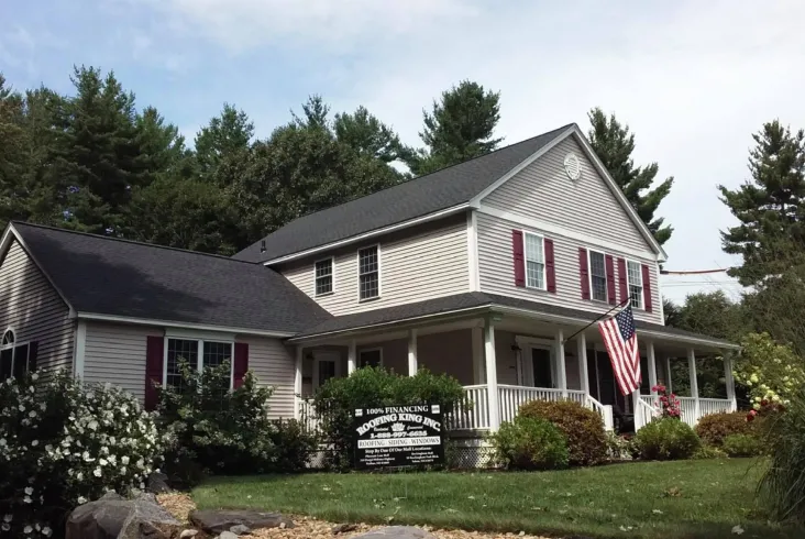 Beige house with an American flag and well-maintained front yard.