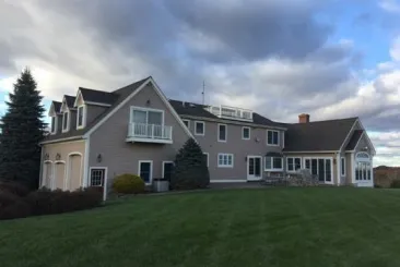 Roofer placing shingles on a roof in Hudson, NH.