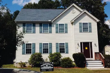 Two-story white house with blue shutters in Billerica, MA.