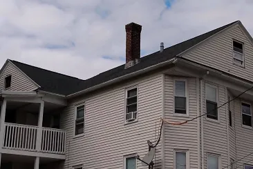 Multi-story home with a dark shingle roof in Natick, MA.
