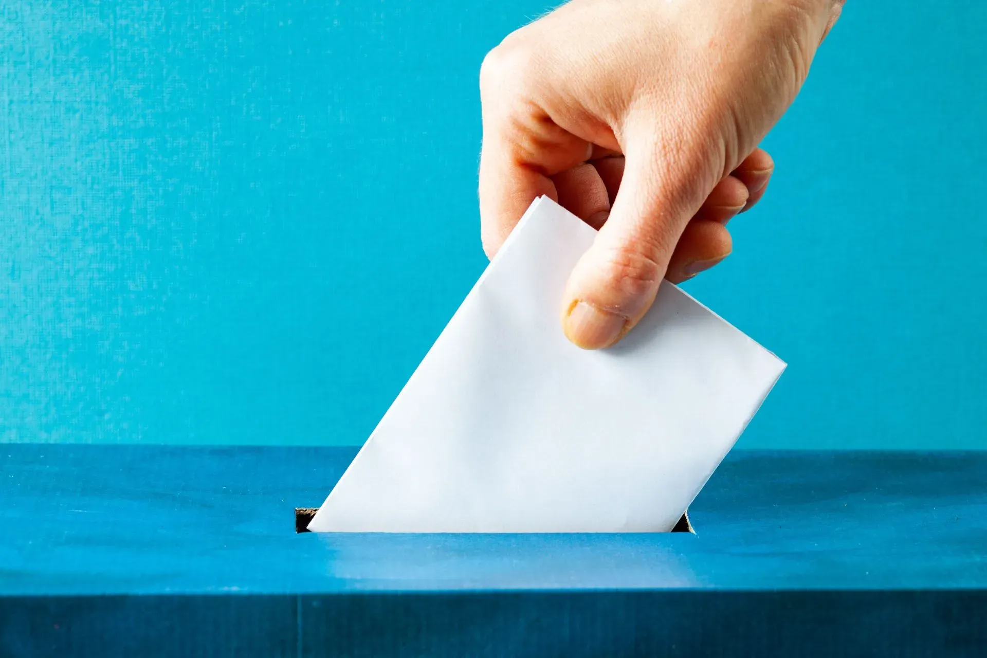 putting ballot in blue election box