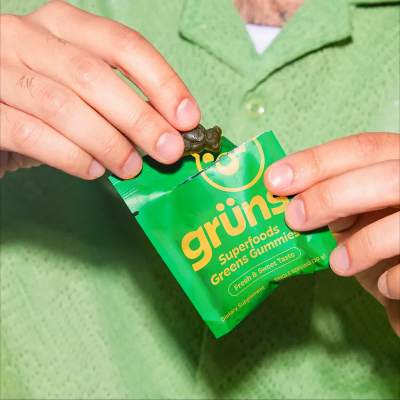 Grüns Superfoods Greens Gummies held in hand