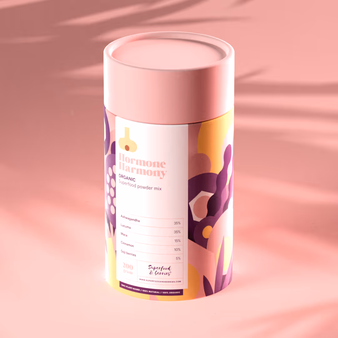 Hormone Harmony -orgaaninen superfood-jauhesekoite, jossa on Ashwagandhaa, Lucumaa, Macaa, kanelia ja gojimarjoja, purkki vaaleanpunaisella kannella ja värikkäällä kuviolla.