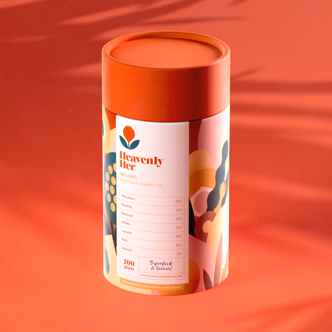 Heavenly Her orgaaninen superfood-jauhe sekoitettu purkki, jossa on kasvi- ja marja-aineita kuten punainen maca, rosehip, punajuuri ja pinaatti, punaruskealla taustalla.