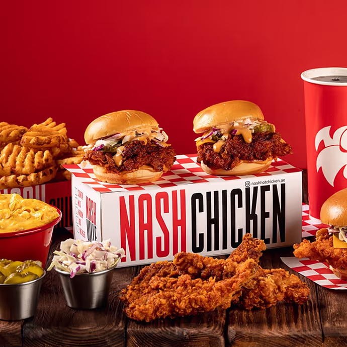 Nash Chicken meal with spicy fried chicken sandwiches, waffle fries, coleslaw, mac and cheese, and a drink.  
