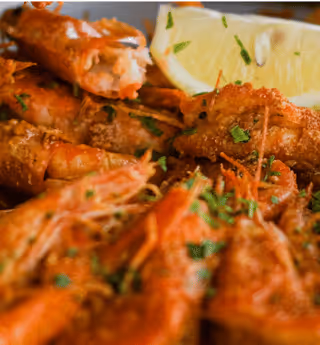 cooked shrimp or prawns garnished with fresh parsley and a lemon wedge