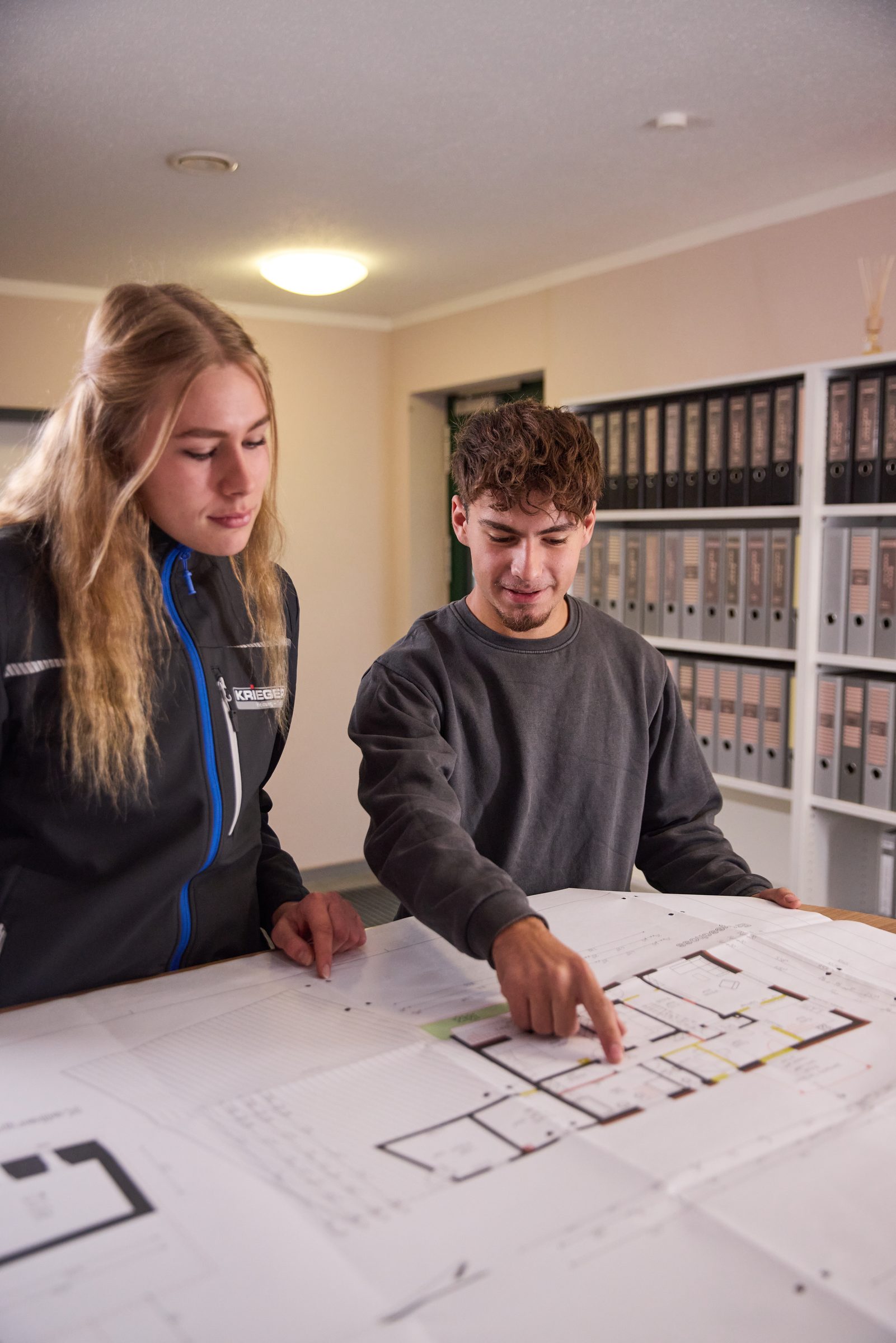 Zwei Krieger Mitarbeitende besprechen einen Bauplan