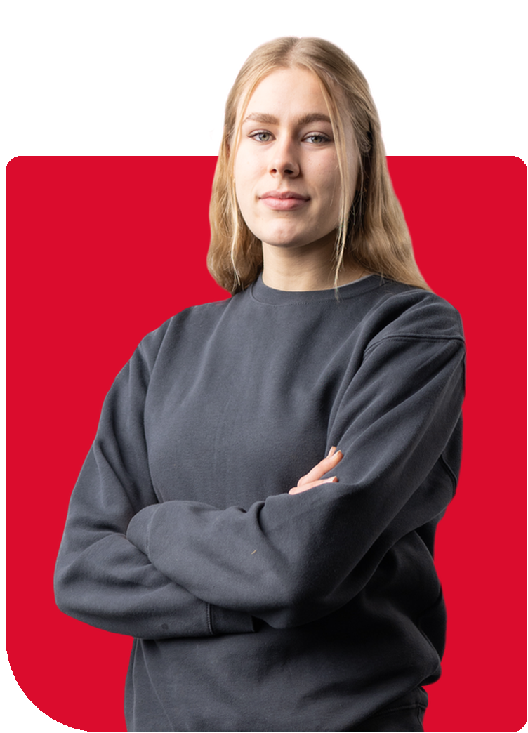 Porträt eines jungen Mannes mit verschränkten Armen vor einem rot-grauen Hintergrund.