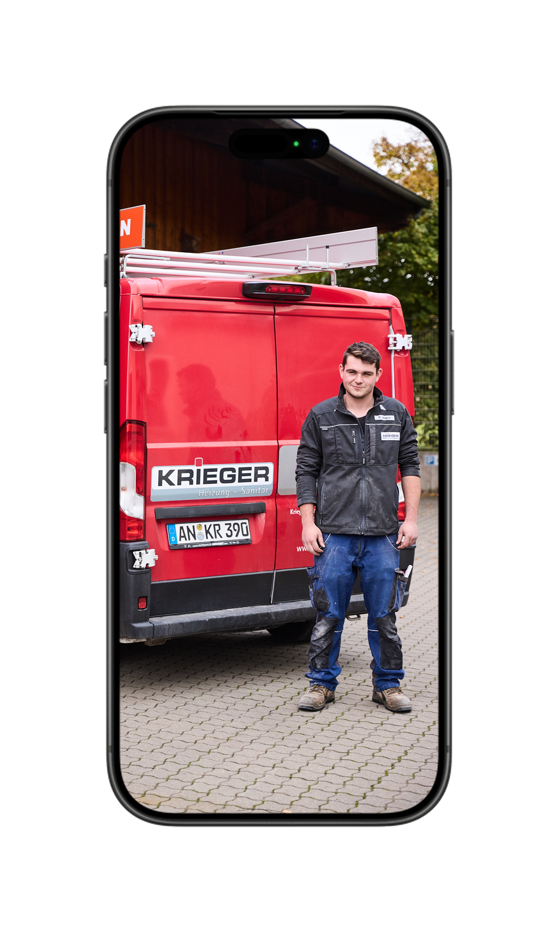 Zwei lächelnde Mitarbeiter stehen vor rotem Hintergrund; der Mann hält eine Rohrzange in der Hand.