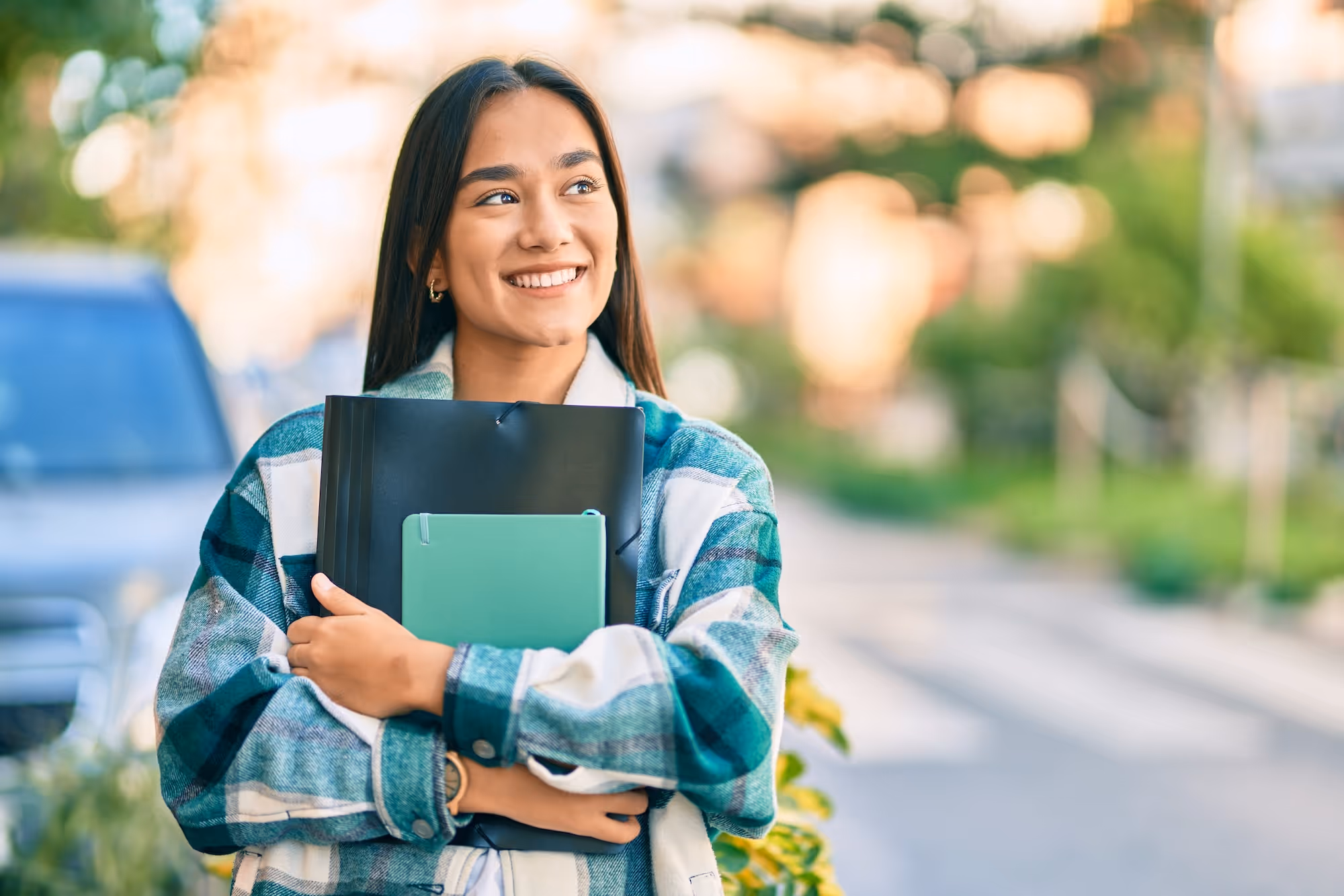 a woman holding files and smiling