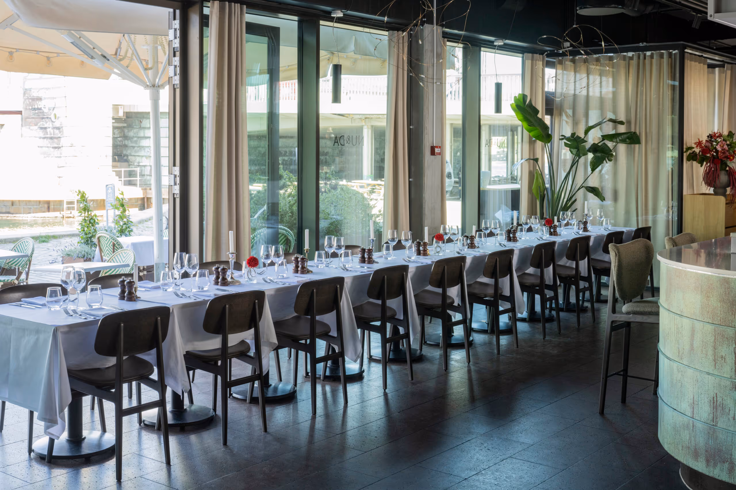 Long table for family dining for a group event at Restaurant NU&DA overlooking Copenhagen harbor.