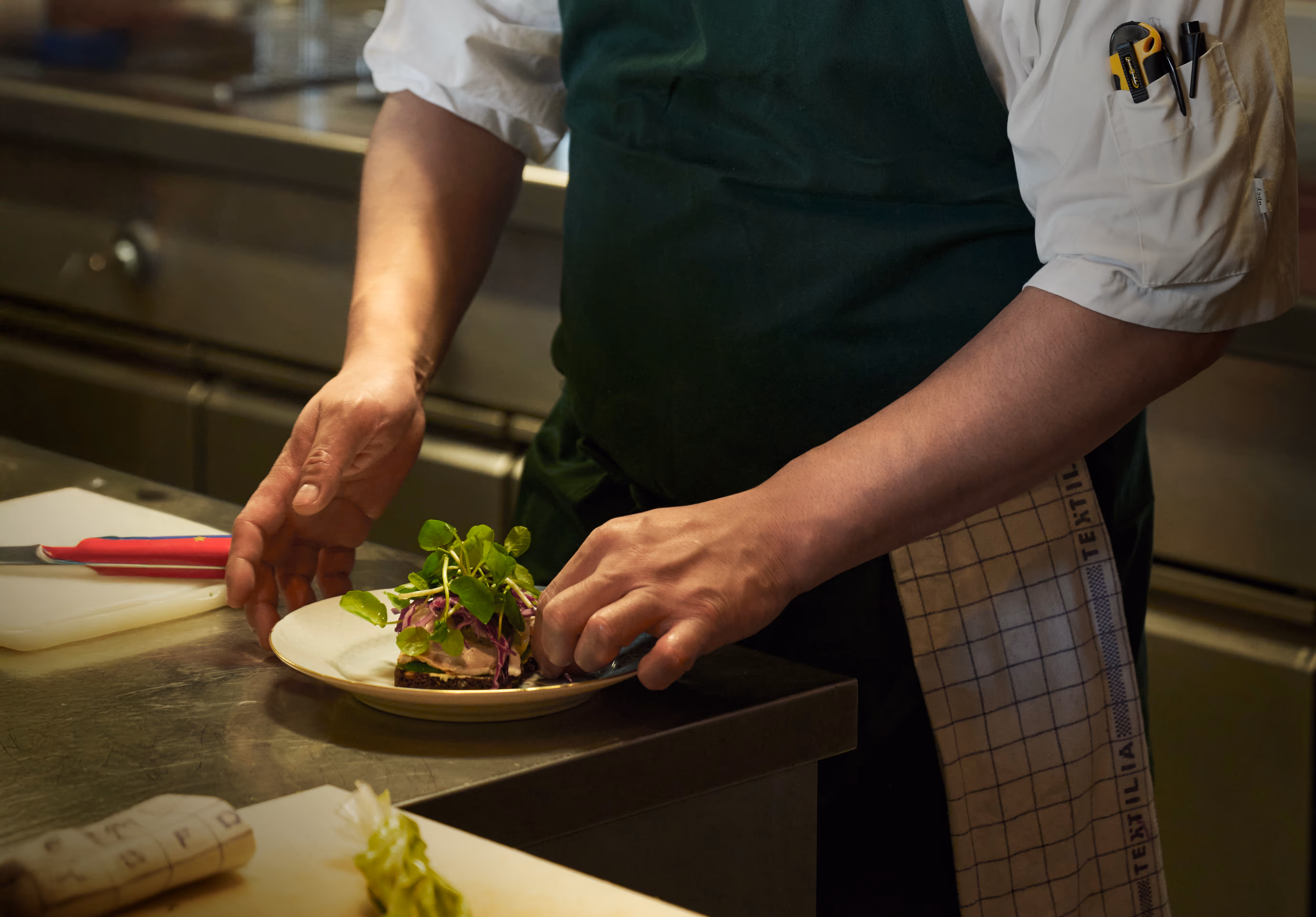 Chef preparing dish to leave the kitchen of Restaurant NU&DA.