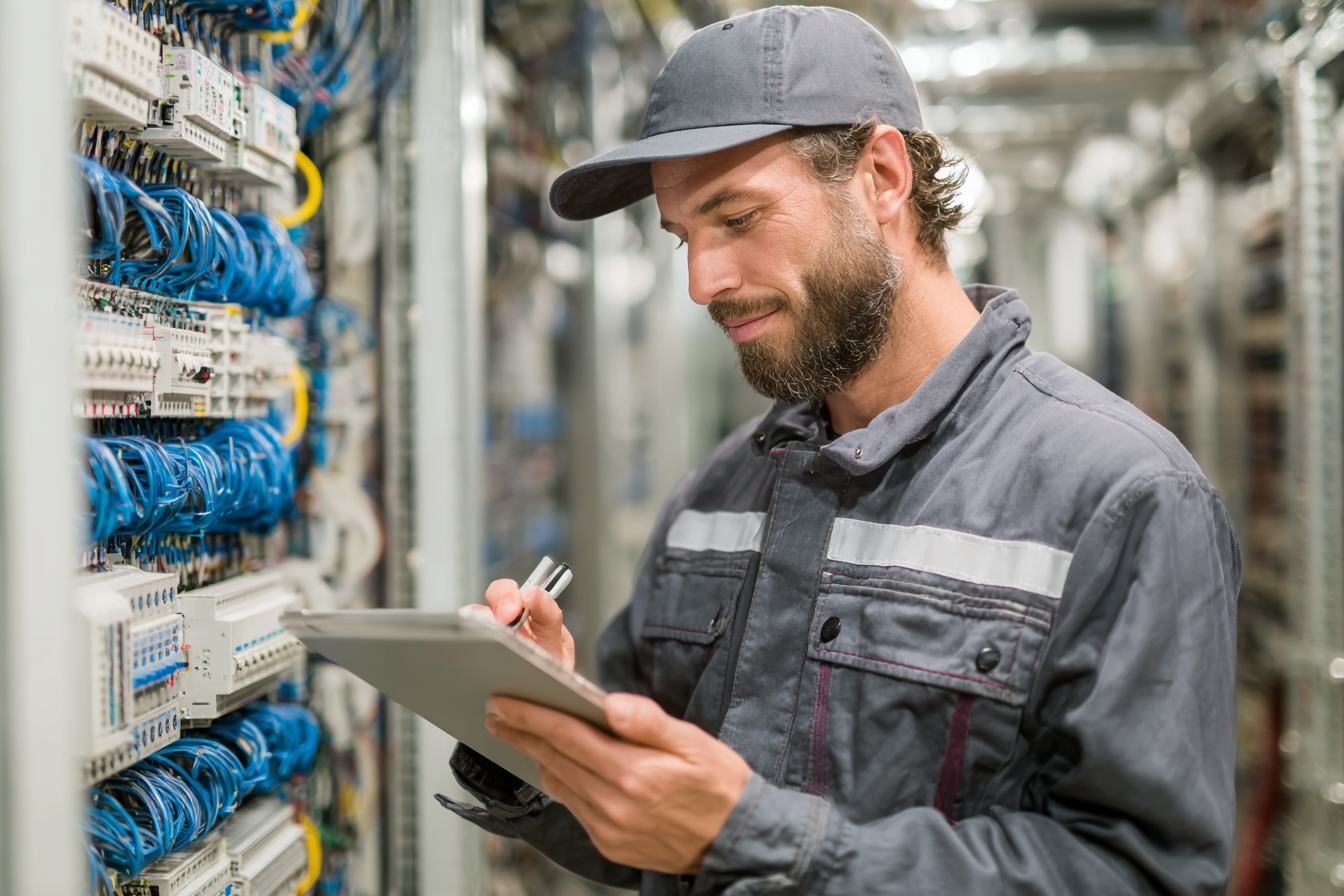 technicien vérifiant un inventaire d’équipement informatique sur une tablette