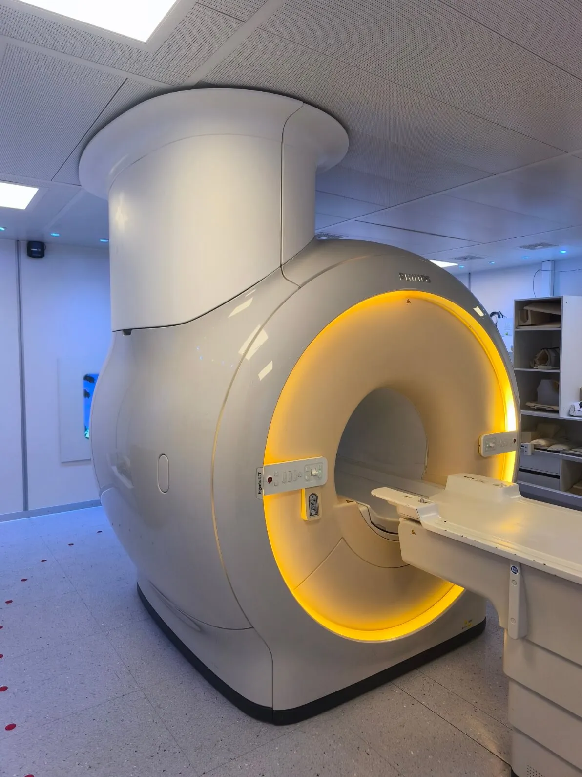 Philips MRI machine with illuminated yellow circular scanner opening in a clinical room.