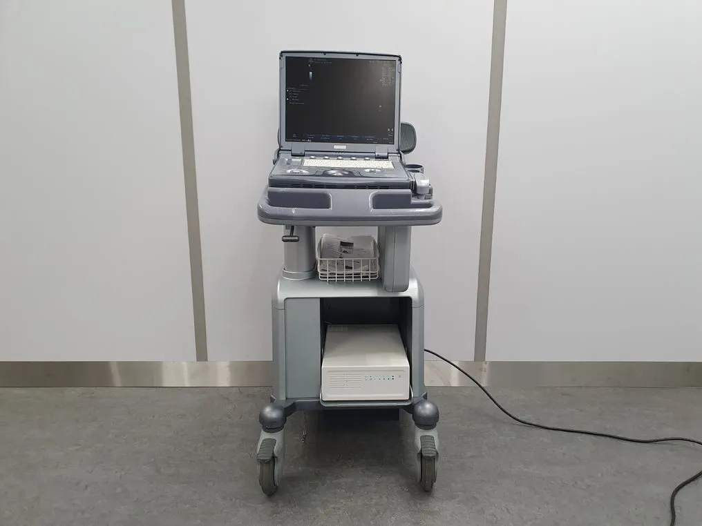 Ultrasound machine on a mobile cart with a screen, control panel, and attached probe.