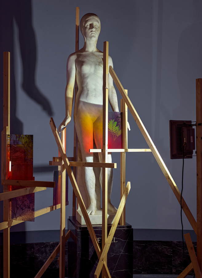 <em>Liminal Spaces</em>, 2025<br/> wood, floodlights, bronze, rowan, linden, hornbeam, sweetgum, plane tree, seeds, fat<br/>1400 × 1400 × 800 cm and undefined