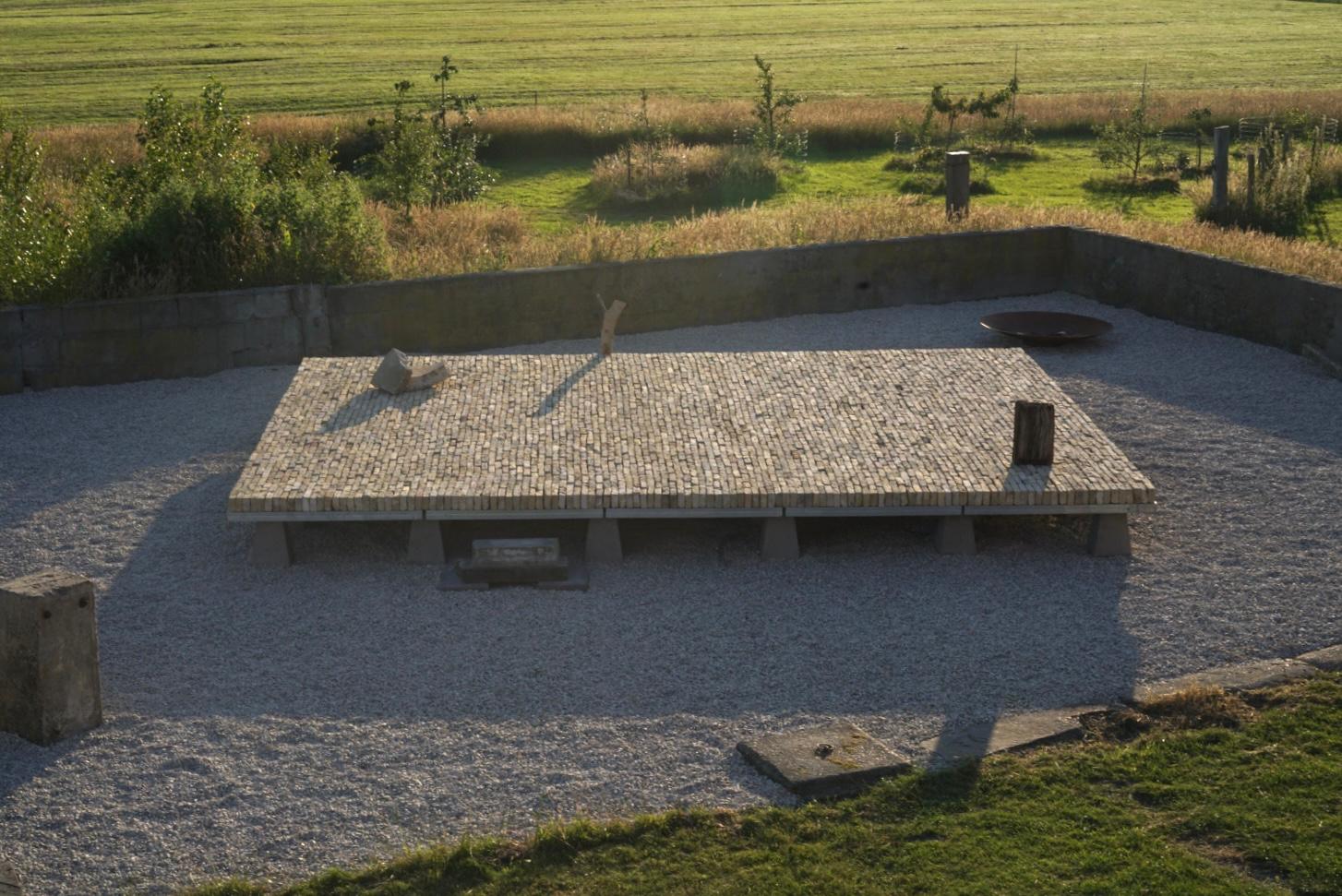 <em>Land, Labor, Love</em>, 2025 <br/>Frisian yellow bricks, wood, concrete, steel<br/>45 × 600 × 300 cm