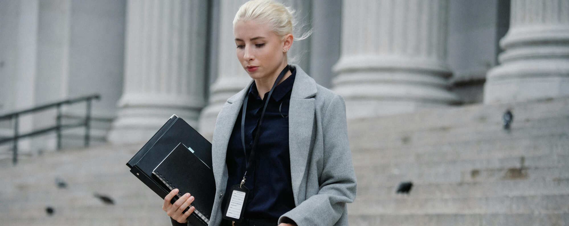 Une femme marchant dans la rue avec un ordinateur portable à la main.