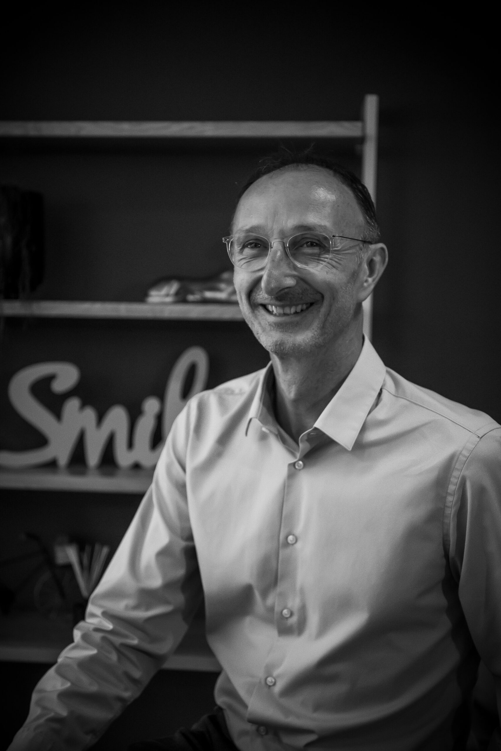 Une photo en noir et blanc d'un homme souriant.