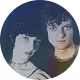 Portrait artistique flou d'un homme et d'une femme avec des expressions neutres sur fond sombre.